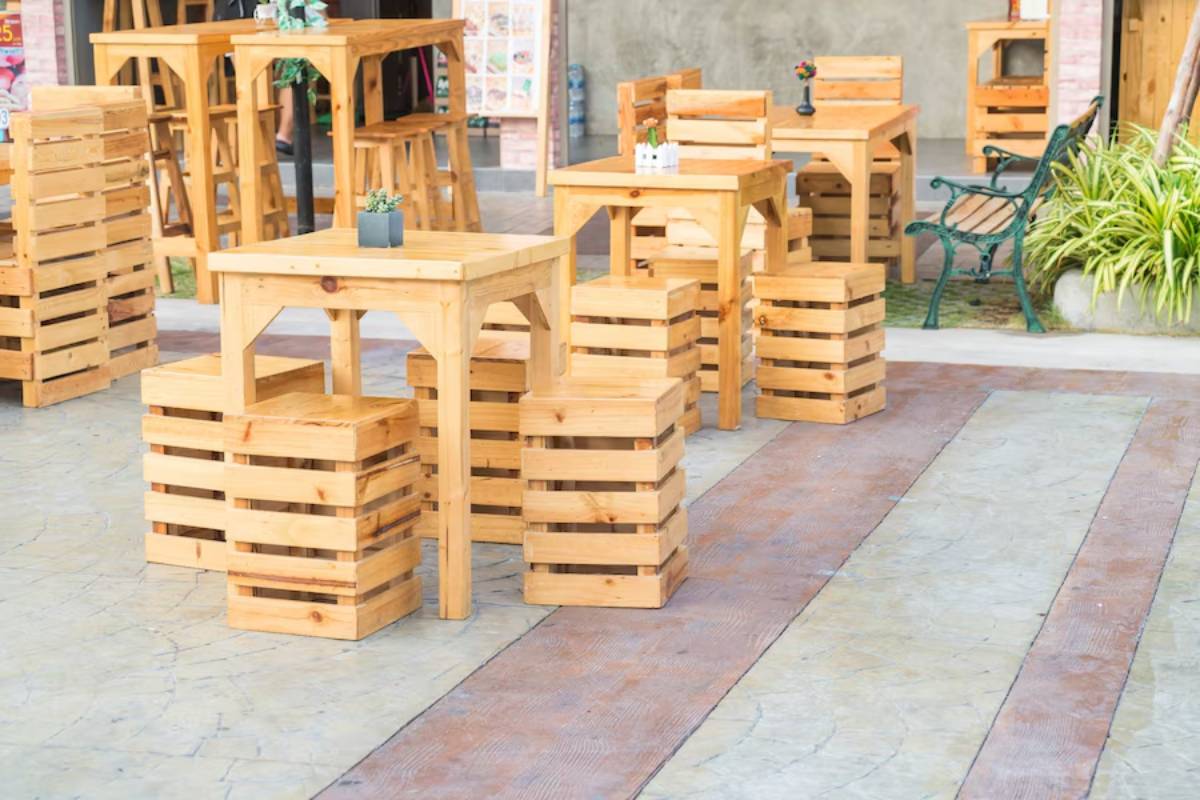 Outdoor café setup with wooden tables and stackable crate seats.