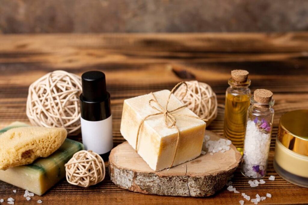 Natural soap bars, essential oil bottles, and bath accessories on a wooden background.